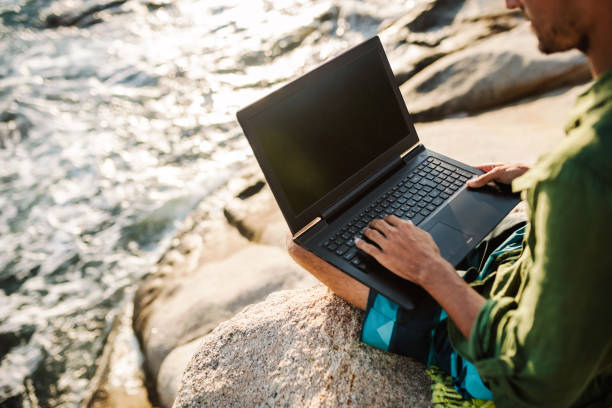 Young digital nomad man working by the sea